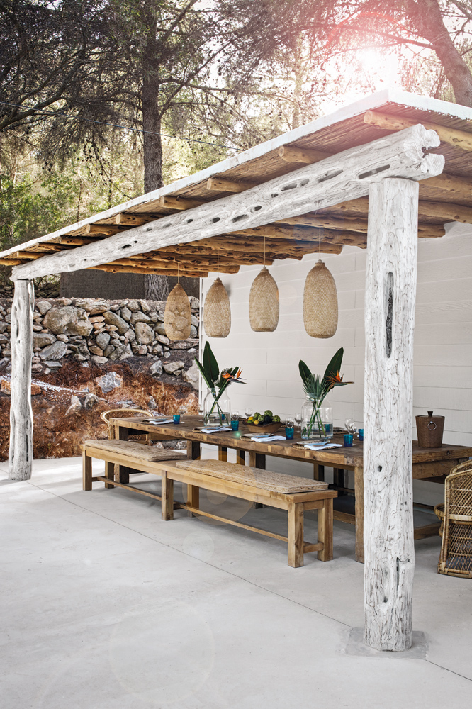 Untreated wood and rattan lend a charming, slightly rugged appeal to the outdoor dining area.