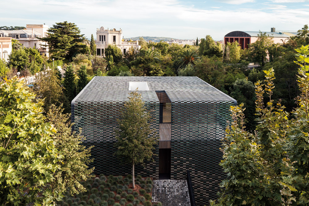 In addition to integrating the home with its environs, the ceramic skin enveloping the cube-shaped structure adds drama.