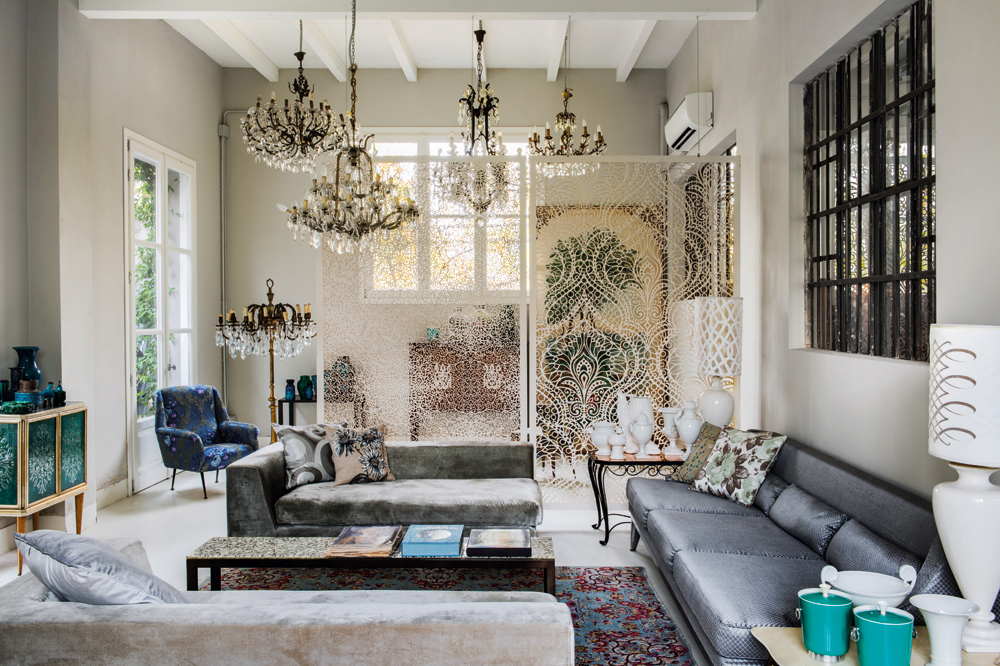 The living room extols opulence with sumptuous silks and velvets from Andrea's own collection, intricate wood panels and antique Bohemian crystal chandeliers.