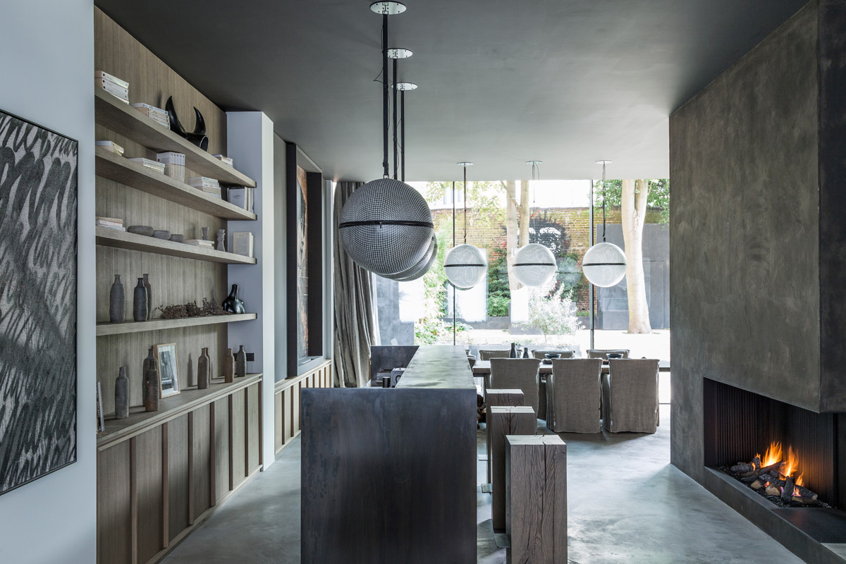 A moody but majestic ambience is set in the dining room bar featuring a fireplace by Dy Puydt. The walls are coated with clay while the floors are in pastellone and the bar in raw steel. Spherical lamps by Coralie Beauchamp complete the look.