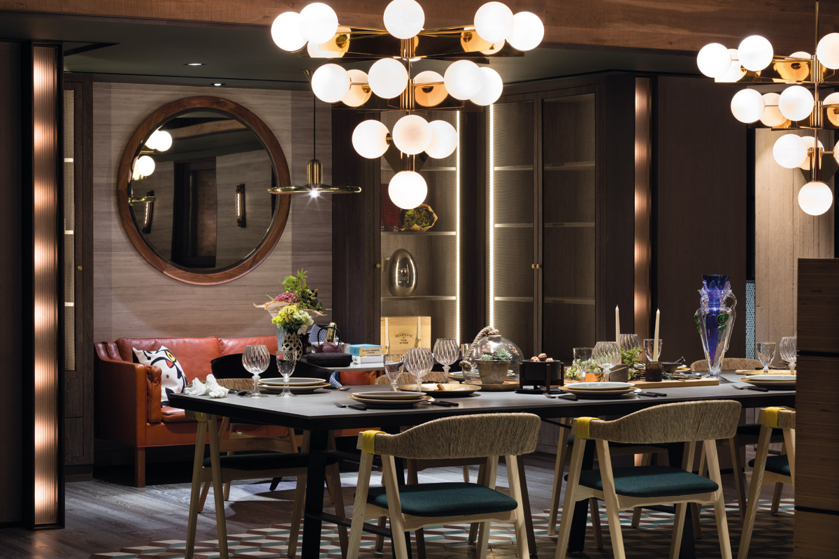 Two of Tom Dixon’s Plane chandeliers hang in tandem above the dining table, dazzling all who gather there. The dining chairs are from Hem.