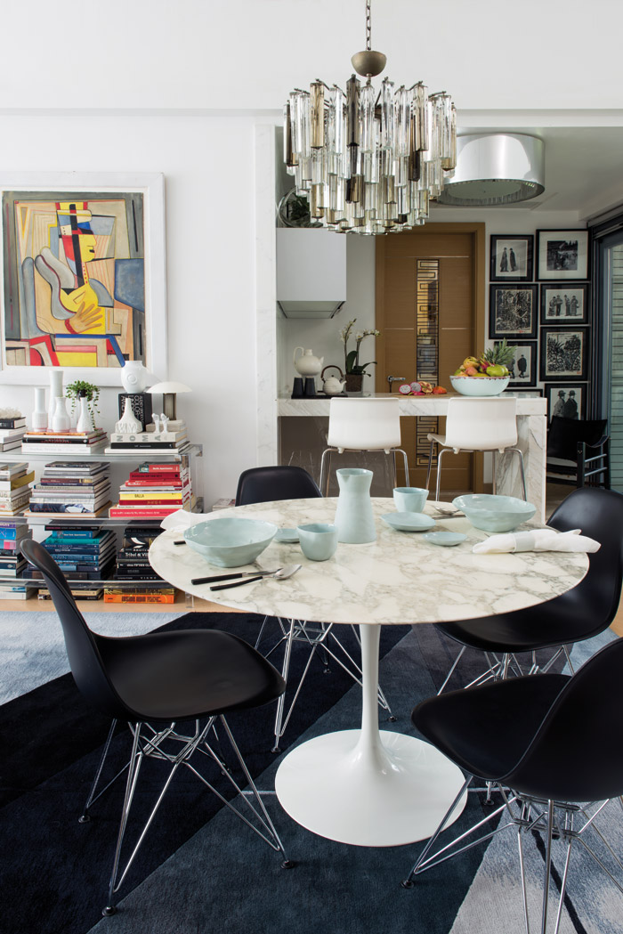A Venini pendant from the 1940s hangs above the dining table. Framed pictures of Ross taken by designer Takeo Kikuchi hang in the kitchen, alongside paintings that he collected while in Japan as a teenager. The leather safari chair is one of Ross’s favourite pieces.