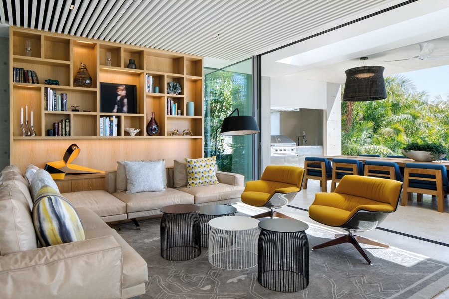 The neutral grey and blue palette that dominates the ground floor is broken up by warm yellow armchairs from Saintluc S.R.L. and a sculpture by Yioryios. (Photo: Adam Letch)
