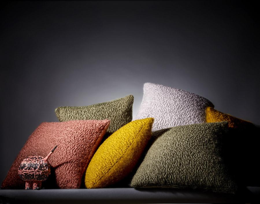The Vermiculation throws and pillows in desert sunset hues feature a wavy organic pattern air-stitched into fleecy mohair