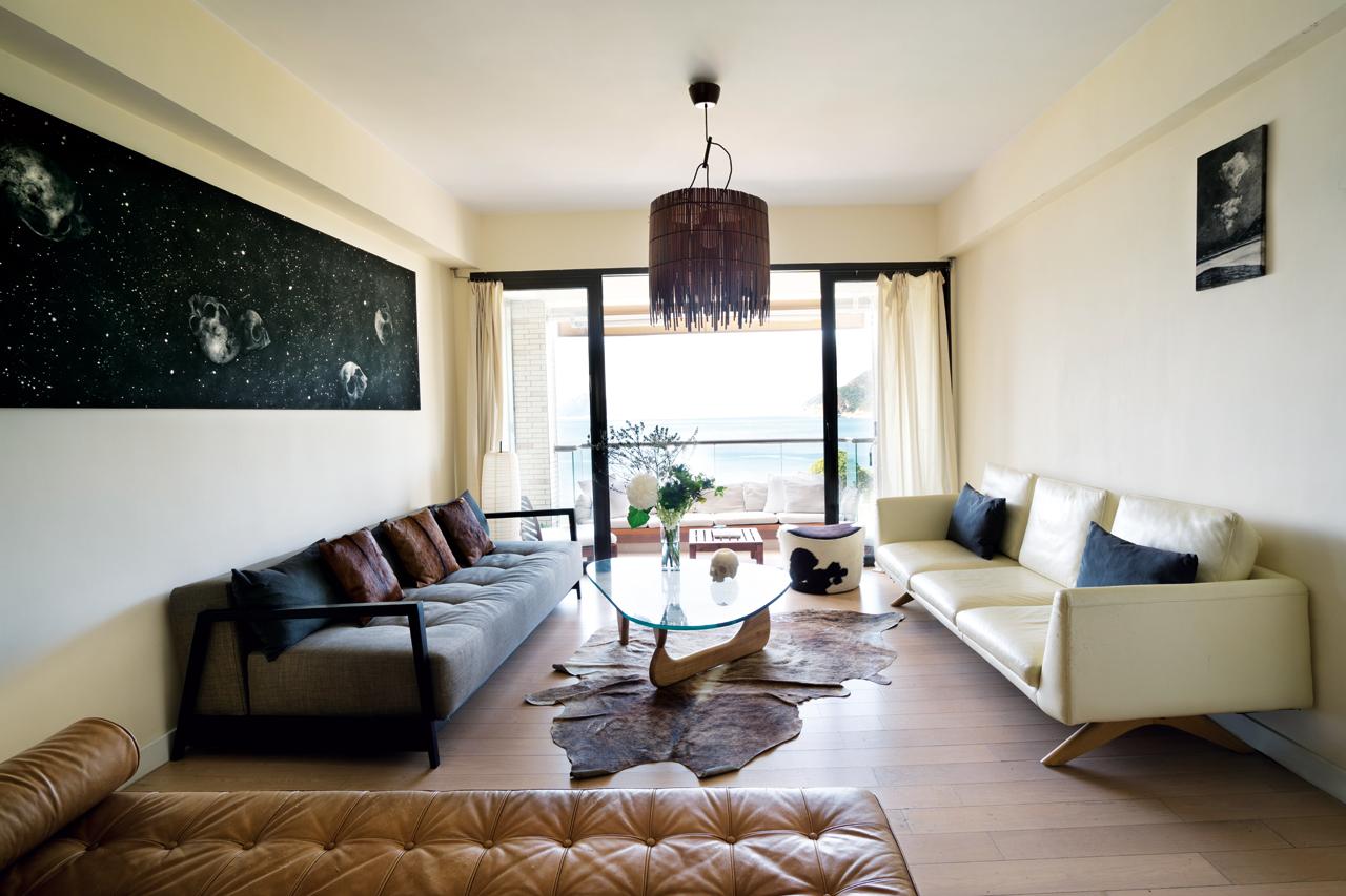 Lalie’s penchant for neutrals, black and white, and materials such as leather shines in the living area; the white wall is sometimes used as a backdrop to project movies