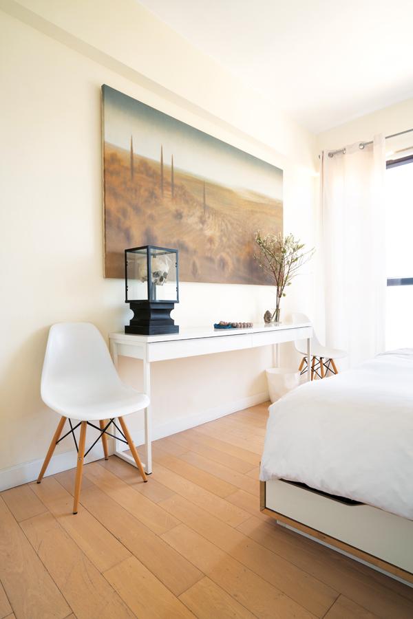 Two DSW dining chairs flank a sideboard in the master bedroom, where Toscani #1 by Didier Eberoni takes pride of place