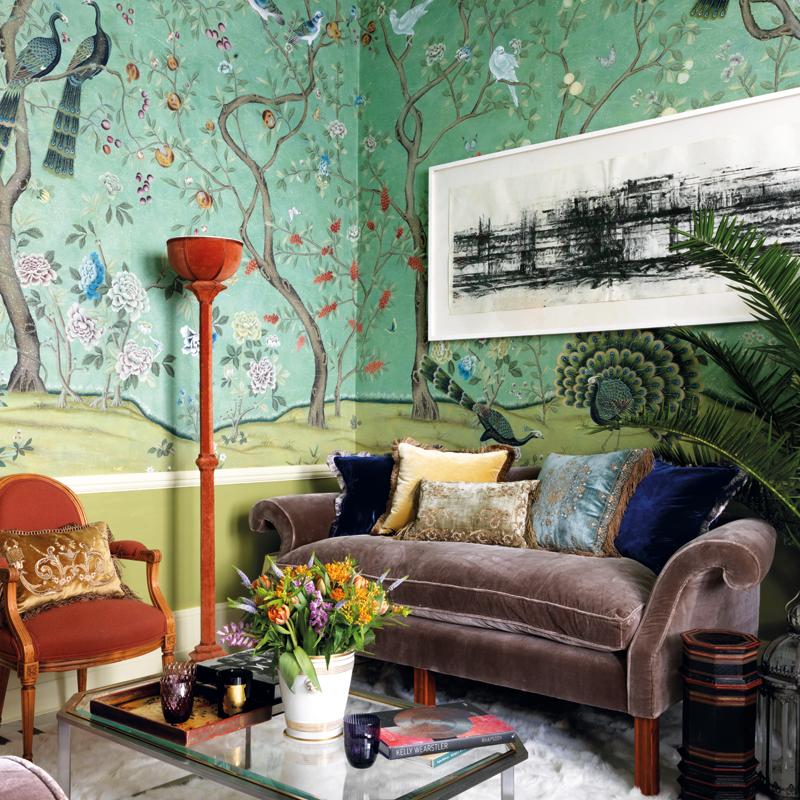 De Gournay's St Laurent wallpaper and velvet upholstery on the sofa mingle with Beaumont & Fletcher cushions and an antique red lamp.