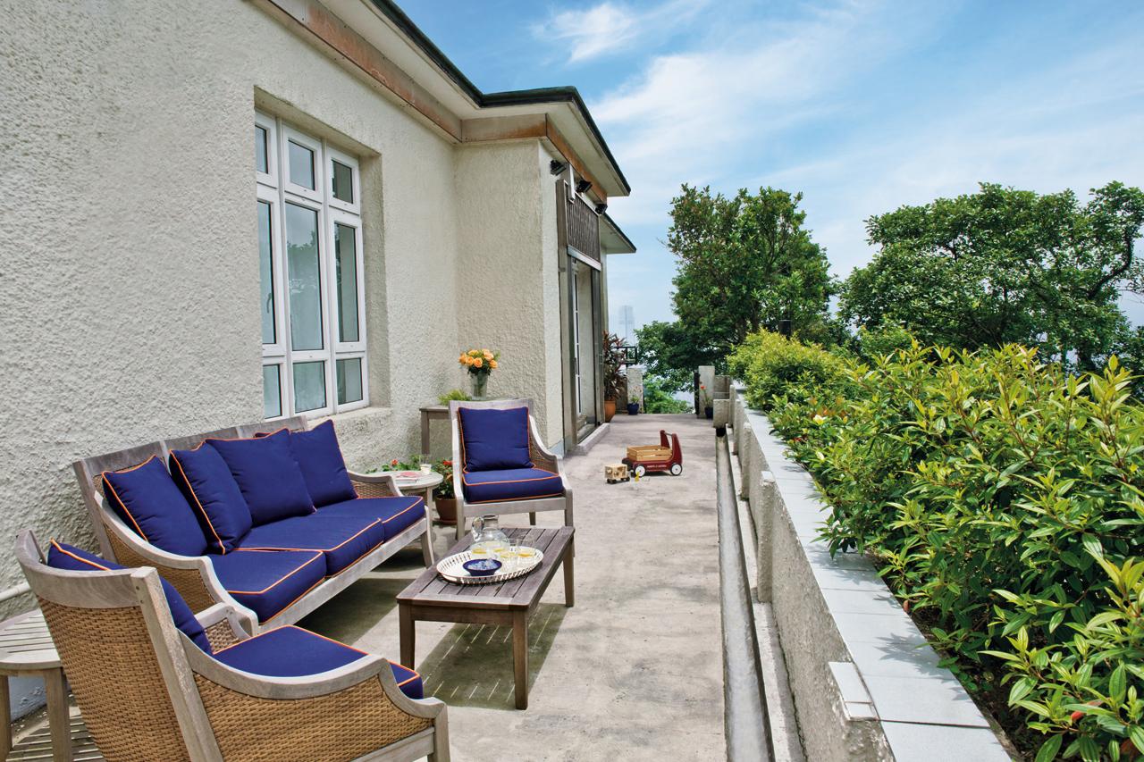The wraparound terrace  is furnished in hardwearing outdoor furnishings in  bold colours.