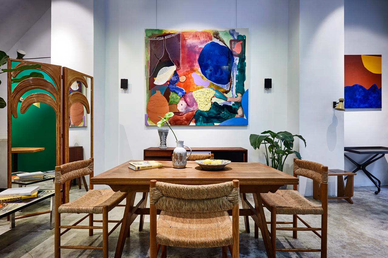Paintings by French artist Jean-François Le Minh adorn the walls; Robert Sentou chairs surround a Rene Gabriel table