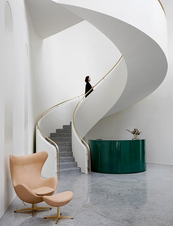 The curving white staircase and terrazo floors (Photo: Courtesy of Fritz Hansen)