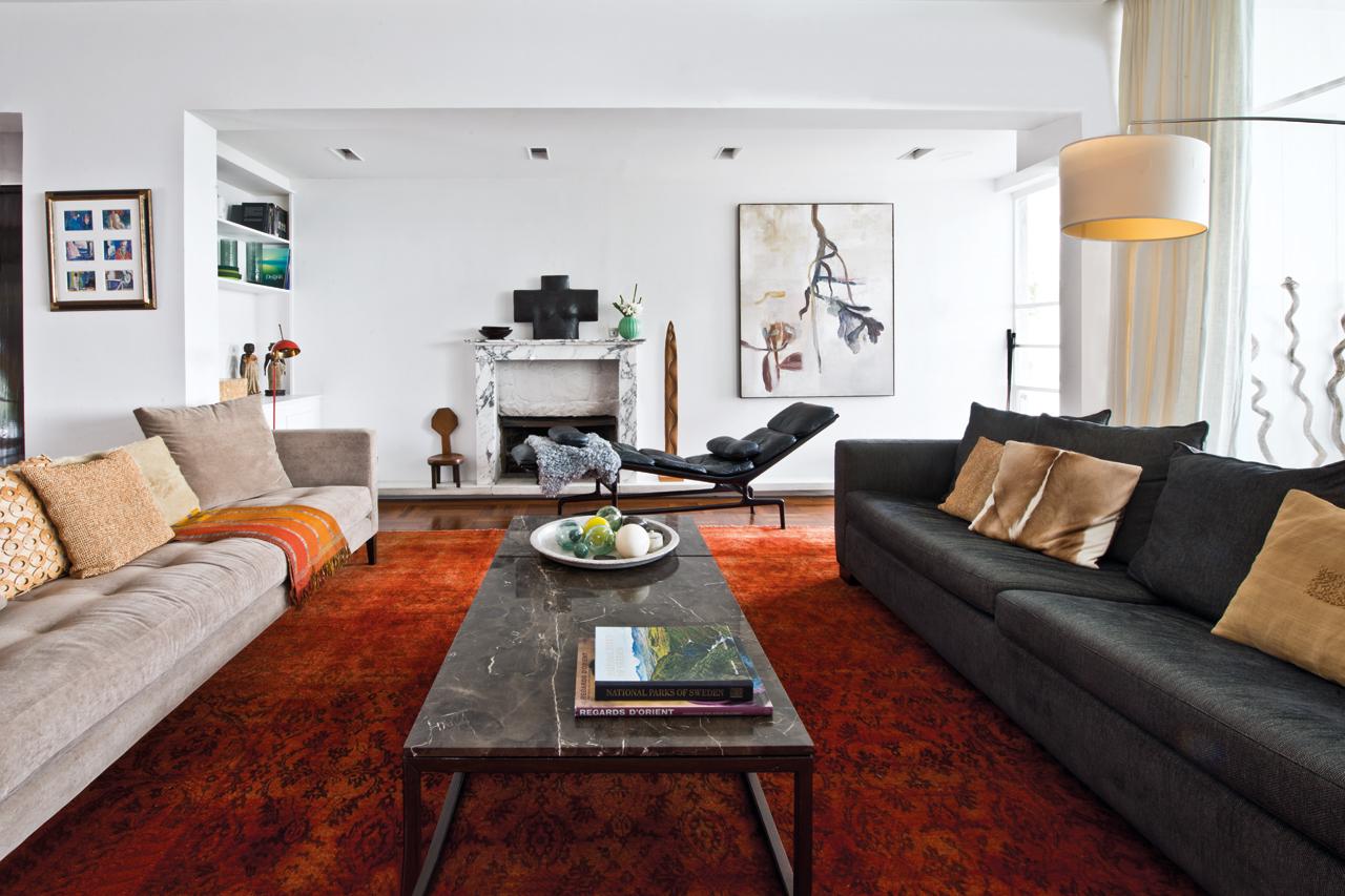 A marble fireplace and an Eames lounge chair add a touch of luxury to the living area