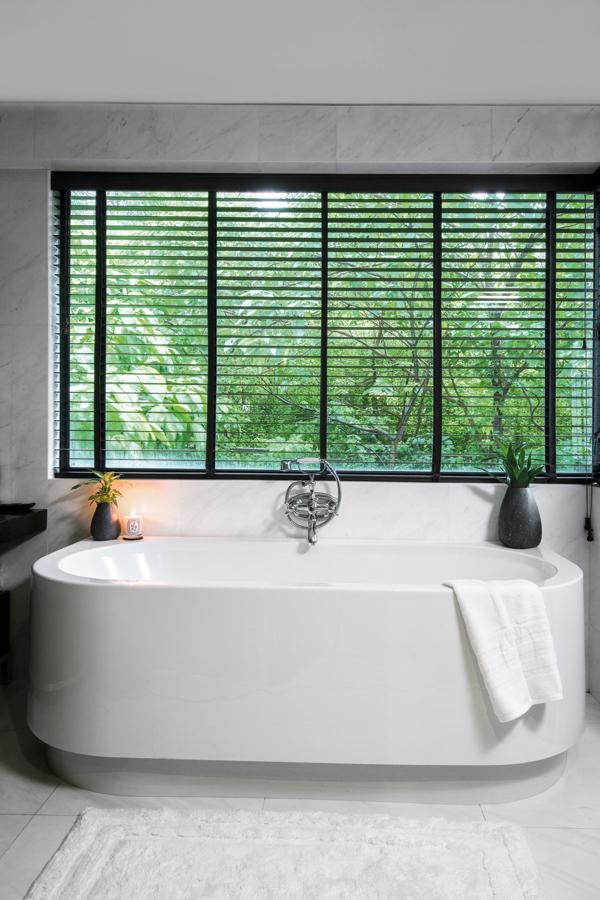 The ensuite bathroom looks out to verdant greenery, which Nick loves. 