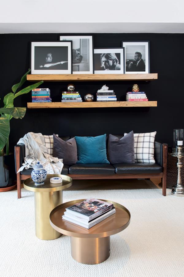In the living room, the Carl Hansen black leather sofa is accessorised with tactile masculine cushions and intriguing photography and curios.