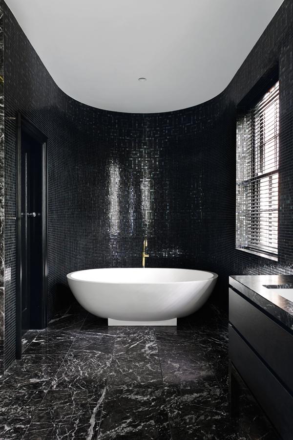 The bathroom features a Haven freestanding bath from Apaiser, Bisazza's Labarinto Nero mosaic tiles and a honed Grigio Carnico marble floor. 