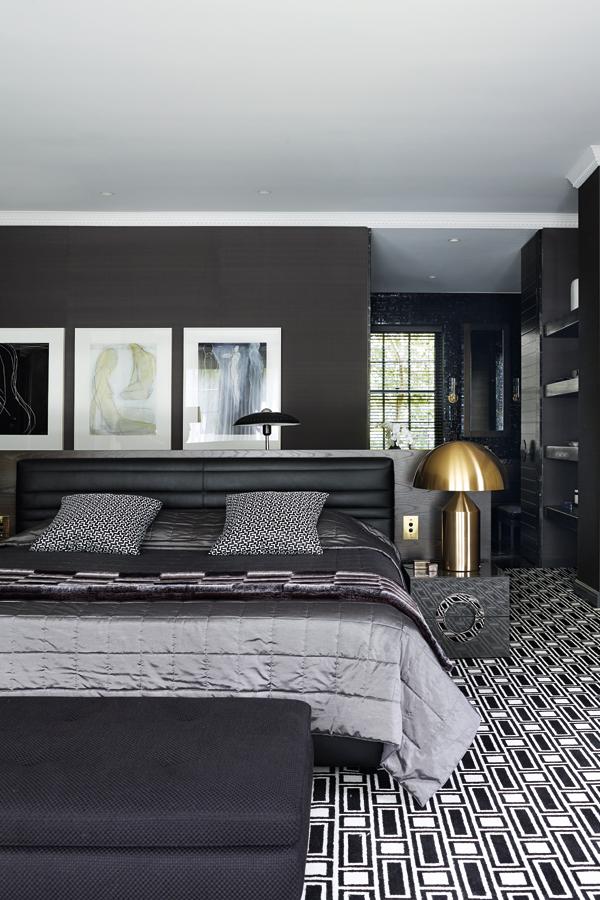A faceted side table by Barbara Barry for Baker is juxtaposed with a geometric carpet by Greg Natale for Designer Rugs; black and white artworks by Adrian Lockhart match the room's monochromatic theme