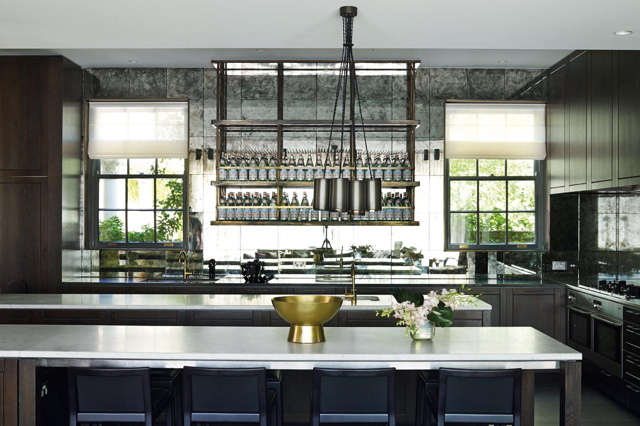 A suspended, custom-made shelf in aged brass provides visual  interest in the kitchen. 
