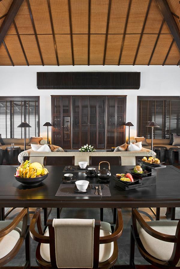 Interiors draw inspiration from Vietnamese design, seen in the wooden screens and thatched roof as well as the soft furnishings made from local silk