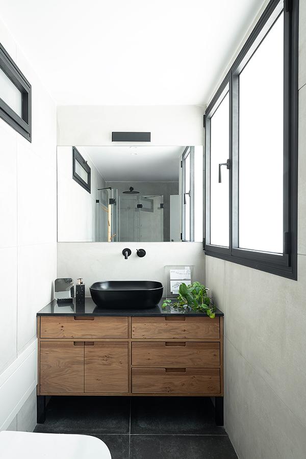 In another of the apartment's bathrooms, a more neutral palette of wood, black and white fall in line with that of the rest of the home
