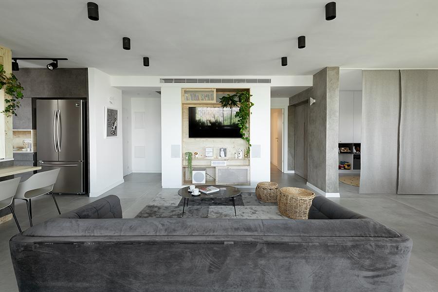 In the living area, a custom-built shelving system houses the entertainment system