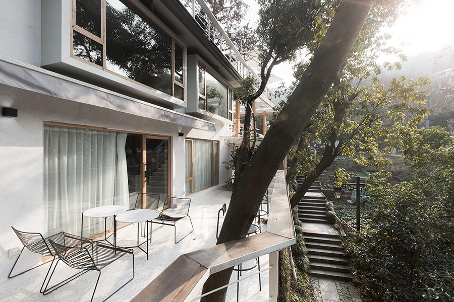 The cafe's original structure has been preserved, and enhanced to mingle with the natural environment, allowing trees in the location to jut through. (Photo: UNITU, courtesy of PROJECT Architects)