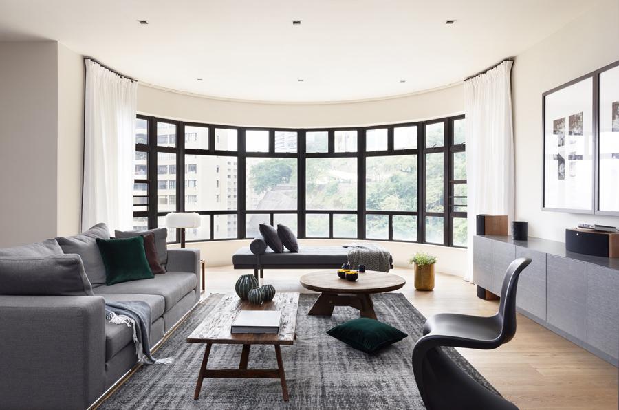 Windows bordered in black steel set the backdrop for this airy, spacious living room where the family hang out