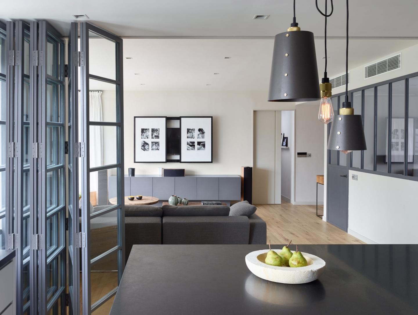 黑鋼框窗為開揚客廳奠下 背景。TREE的裝飾、墊子、  地墊和咖啡桌各見魅力，與灰色沙發系統互相映襯