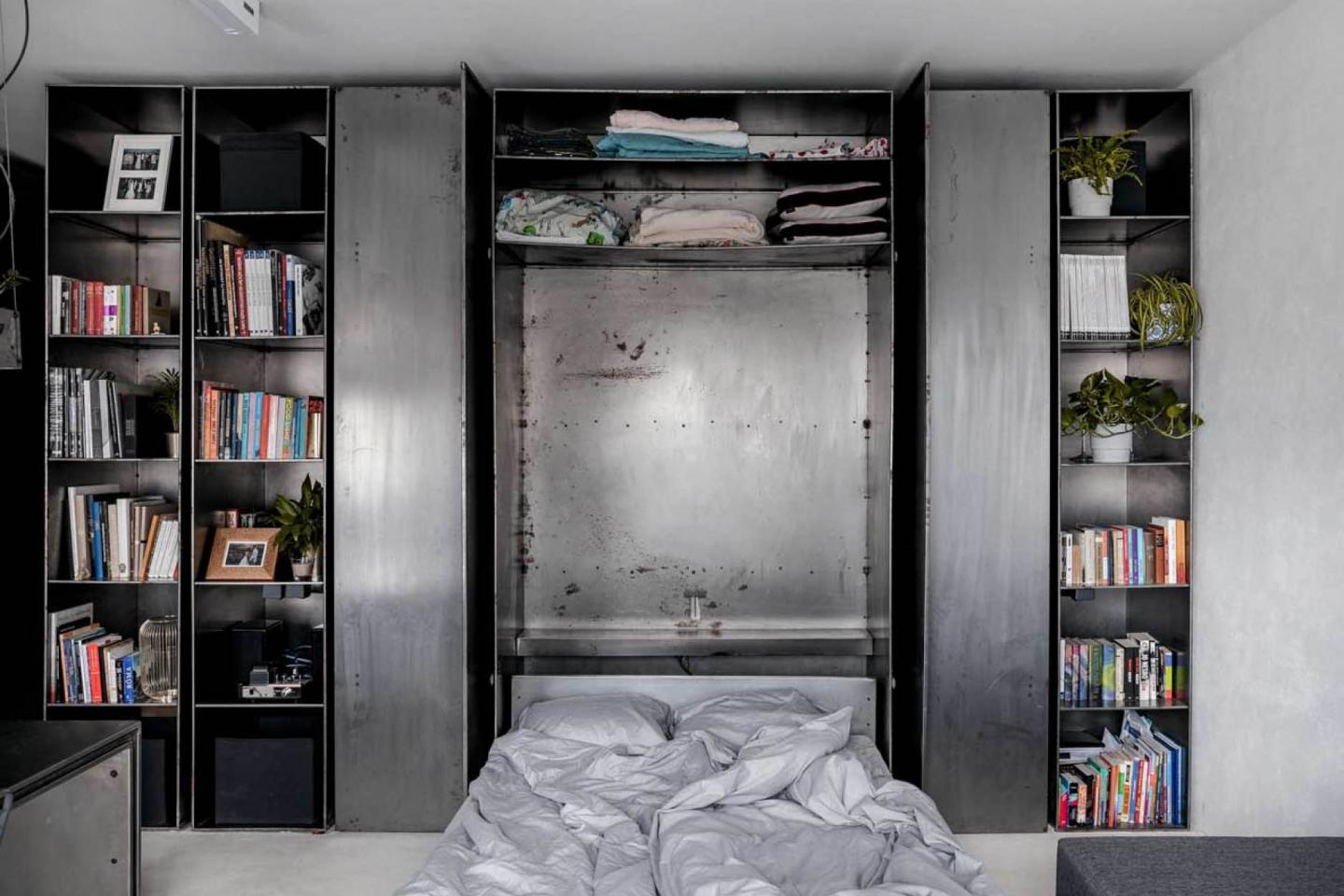 一如廚房的巧妙收納設計，把書架中間的牆板拉下即見睡床