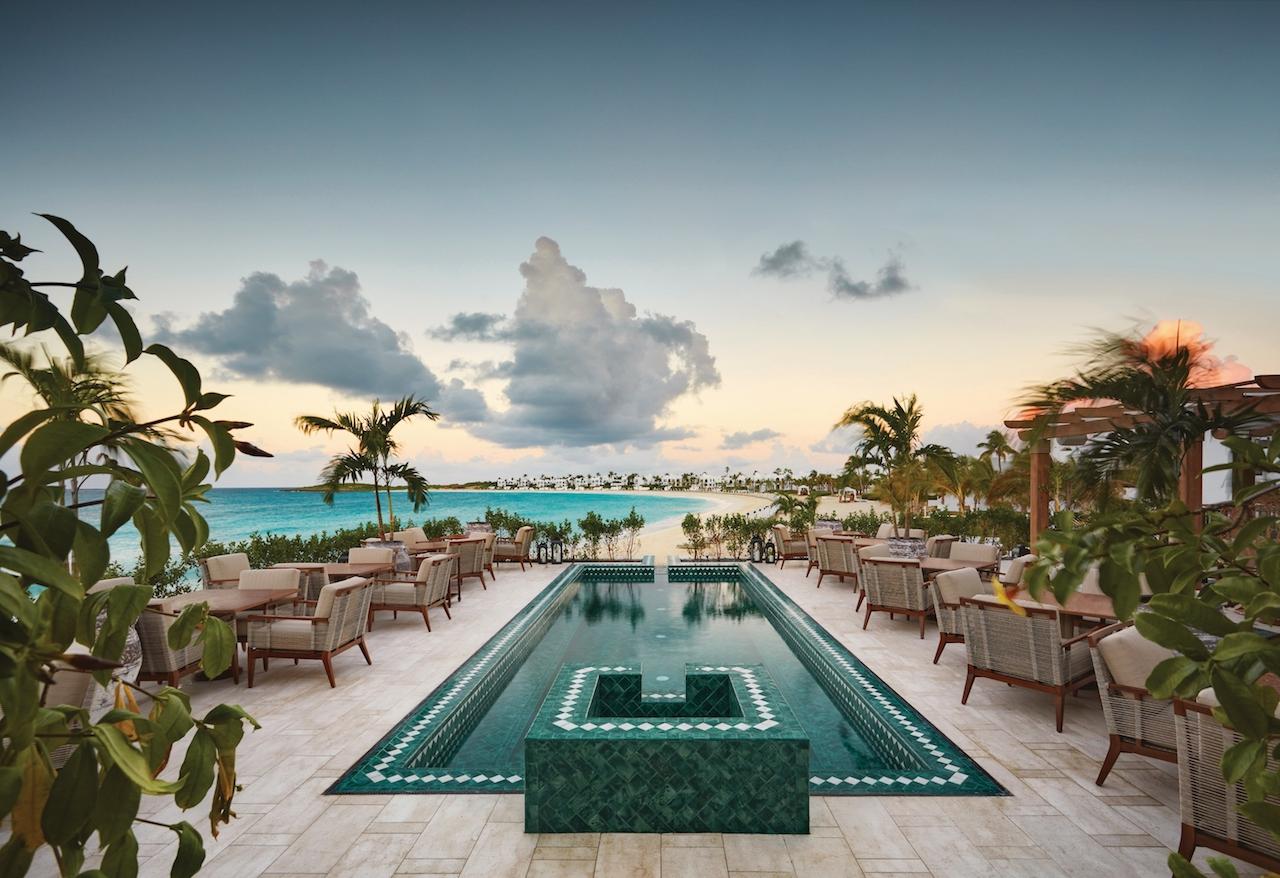 The outdoor terrace features an infinity edge pool with tiles that complement the resort's Greco-Moorish architecture