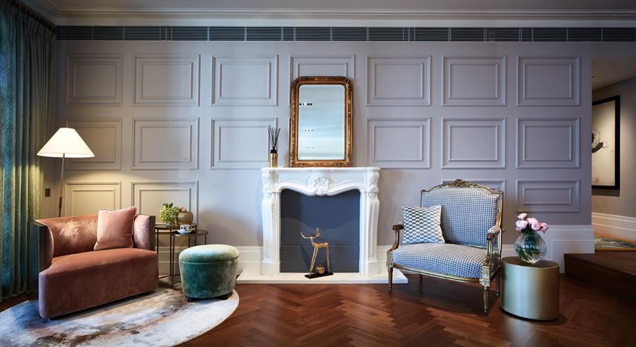 A fireplace against pale blue walls and mouldings transposes a little bit of New York and Paris into the Mid-Levels abode