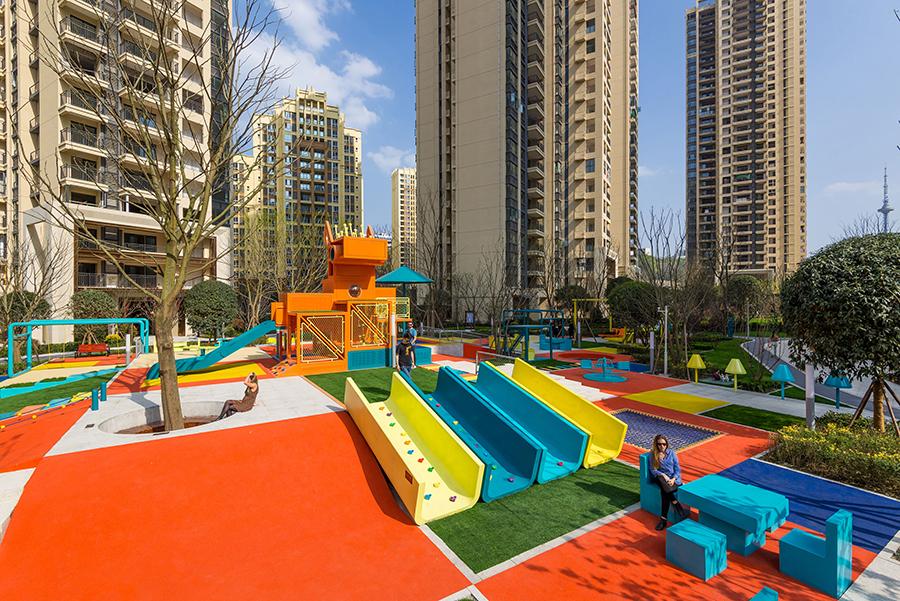 Colourful slides on a gentle slope lead to a picnic area complete with tables and seating. (Photo: Courtesy of 100architects)