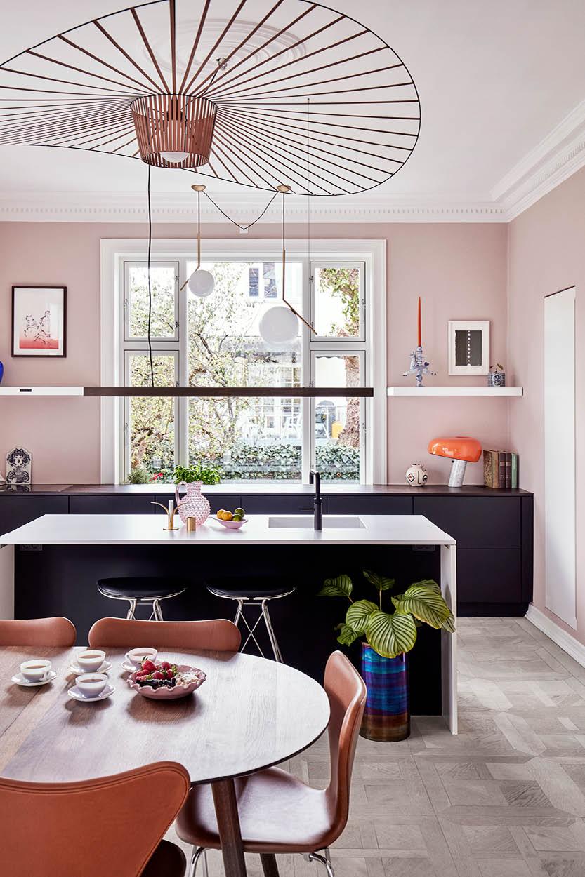 飯廳以柔和的玫瑰色牆身裝飾， 再加上Fritz Hansen椅、Constance Guisset為Petite Friture設計的Vertigo銅製吊燈，魅力超然