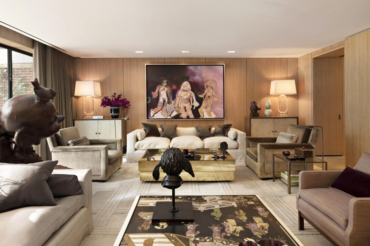 Oak wood wall panelling set the scene for the television room, where a painting by Richard Prince hangs above a custom-made sofa by Jonas and a brass Gabriella Crespi low table from Nilufar