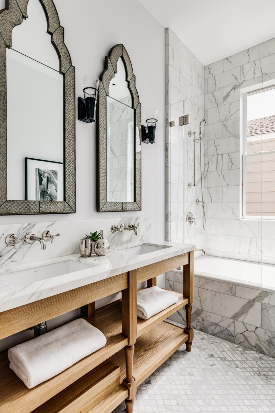 Marble finishes and shiny tiles commingle with wood and natural materials to meld luxury and rustic charm in two of the home's four bathrooms
