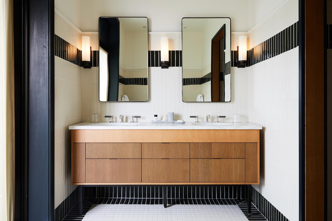 A guest bathroom equipped with double sinks and mirrors 