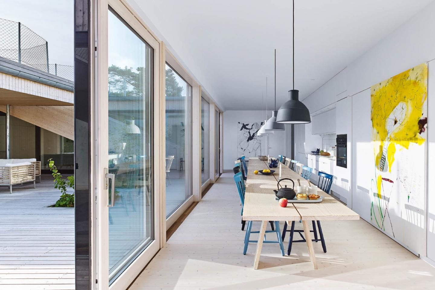 An impressive dining table based on a traditional trestle design runs the length of the open-plan kitchen and dining  area, seating up to 26 people