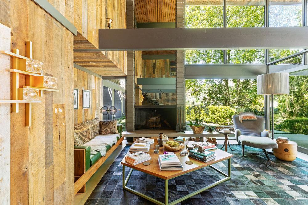 The heavily timbered 1960 home boasts a 2-storey fireplace wall