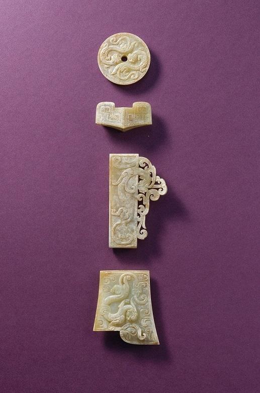 An important set of three jade ‘chilong’ sword fittings and a jade sword guard Western Han dynasty (206 BC-AD 8). The largest: 3 1/2 in. (8.8 cm.) wide. HK$1,800,000-3,000,000