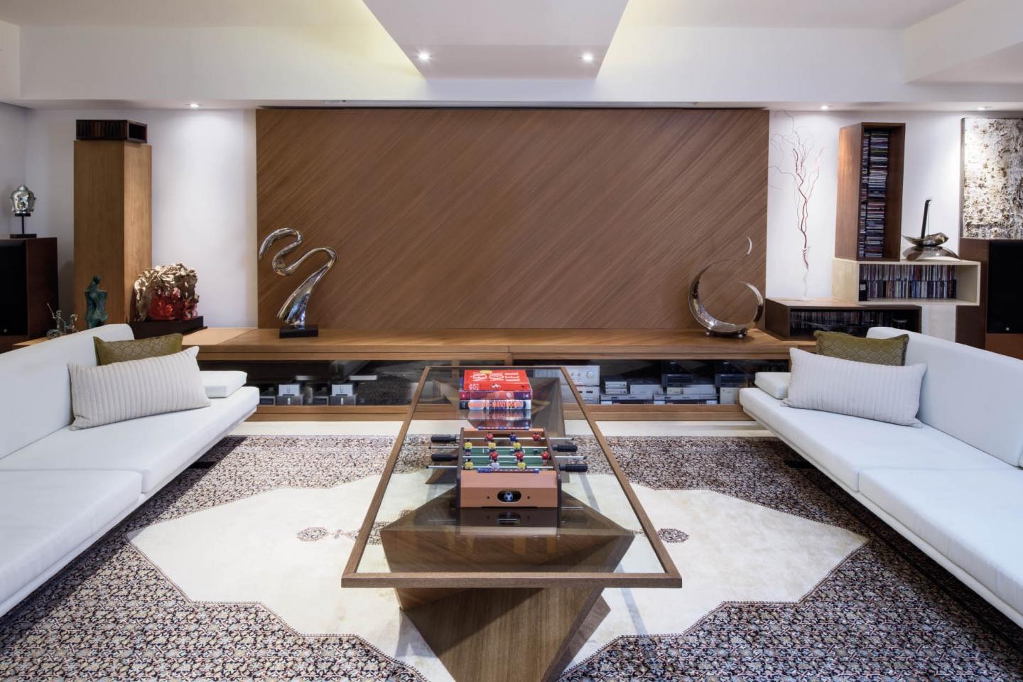 Clean lines, white walls, wood panels and structured sofas create the impression of a contemporary conversation pit
