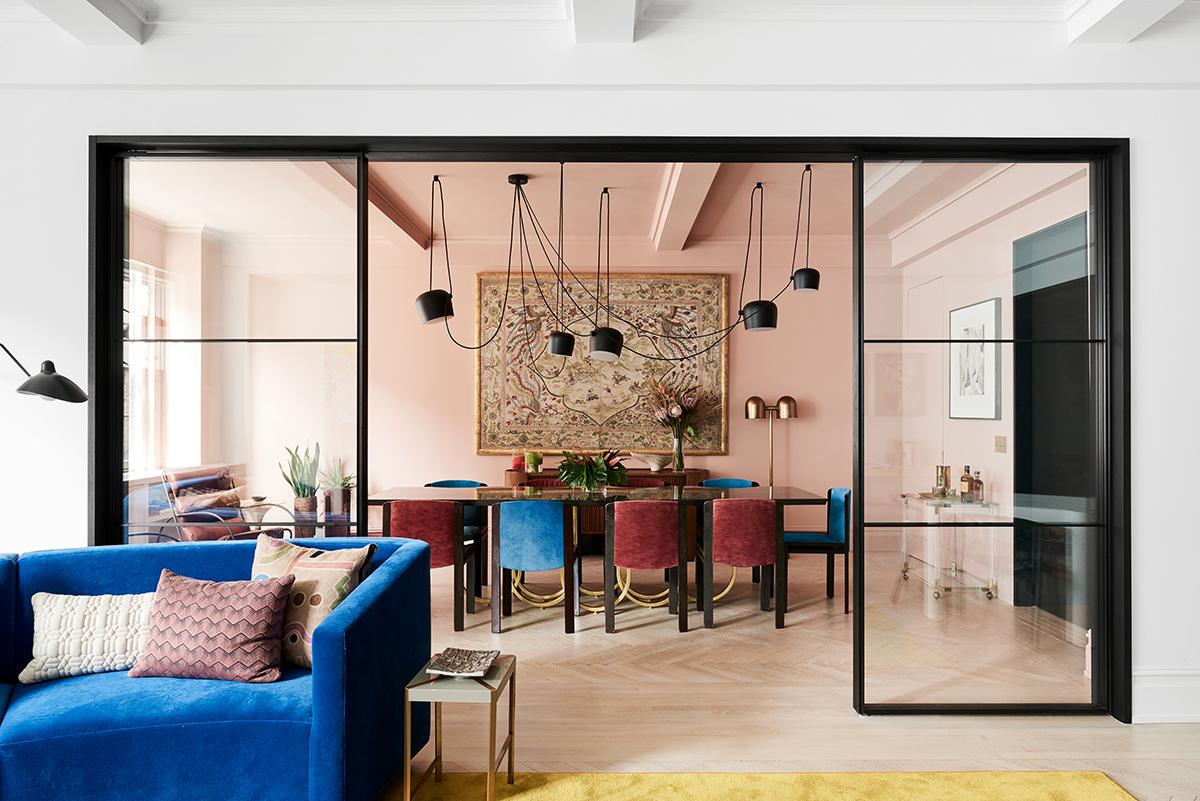 The elegant dining room, dressed in pink, is anchored by an 11ft custom-designed table in high gloss lacquer, steel, and gold lead, by Detroit designers Alex Drew and No One. The table is surrounded by vintage Joe Colombo dining chairs in original fabric. (Photo: Brooke Holm)