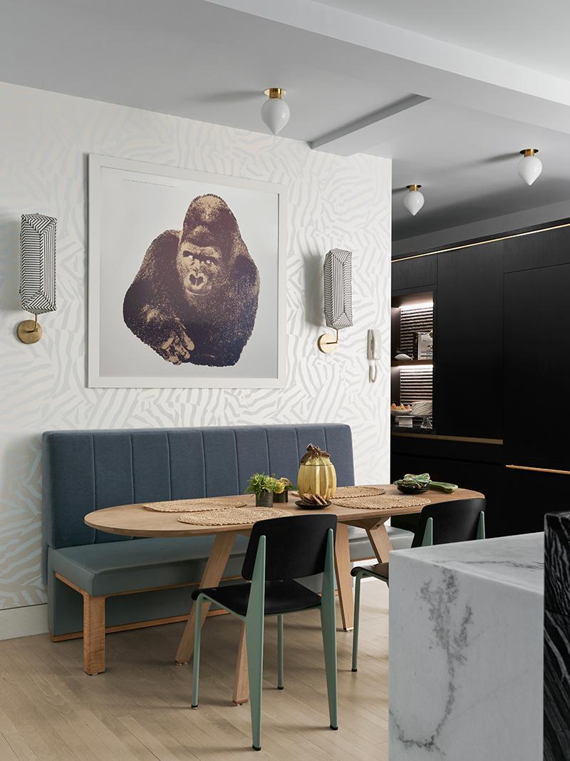 A gorilla print by Enzo Mari hangs above the dining table, flanked by fabric sconces by Erich Ginder. (Photo: Brooke Holm)