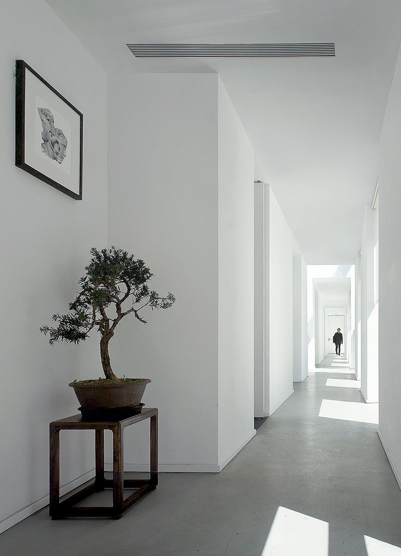 A serene corridor, lit by daylight through block-like windows to the side, connects the house's various areas. (Photo: Linjian Design Studio)