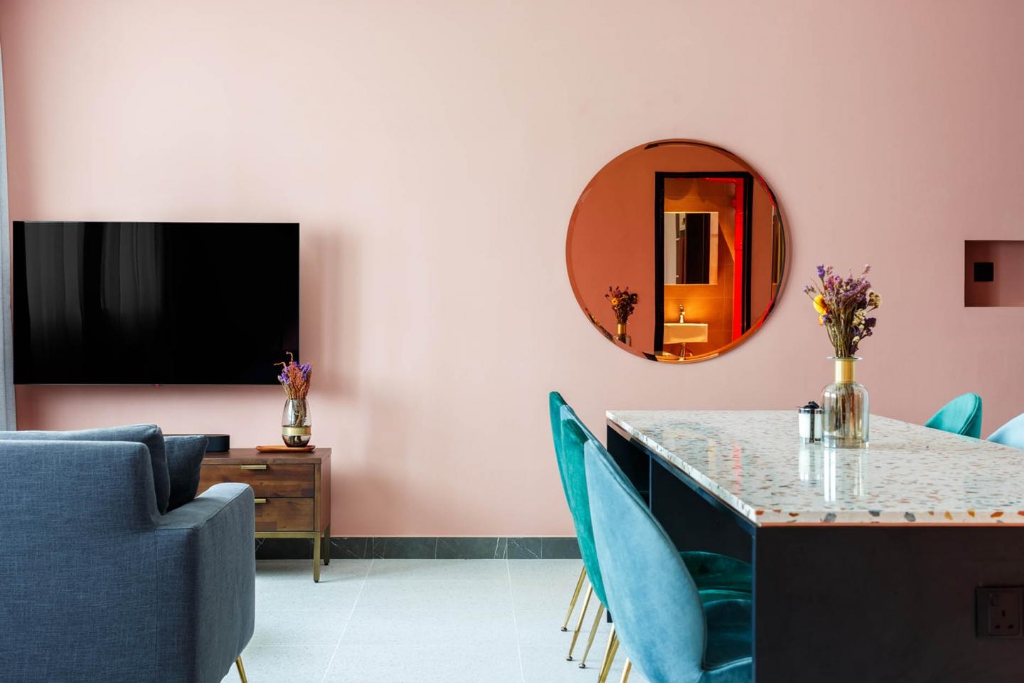 客飯廳以粉色作背景，再加上柔和而矚目的水磨石檯面設計，還有渾圓的著色掛牆鏡，打造焦點處處的室內設計