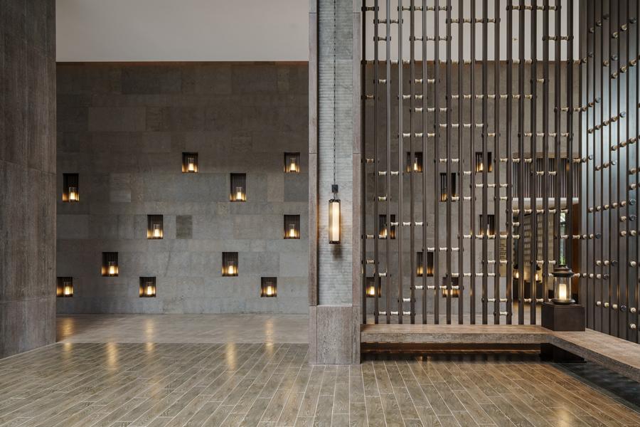 Dark timber tiles, bronze-detailed ceiling and gently lit lanterns imbue the interior