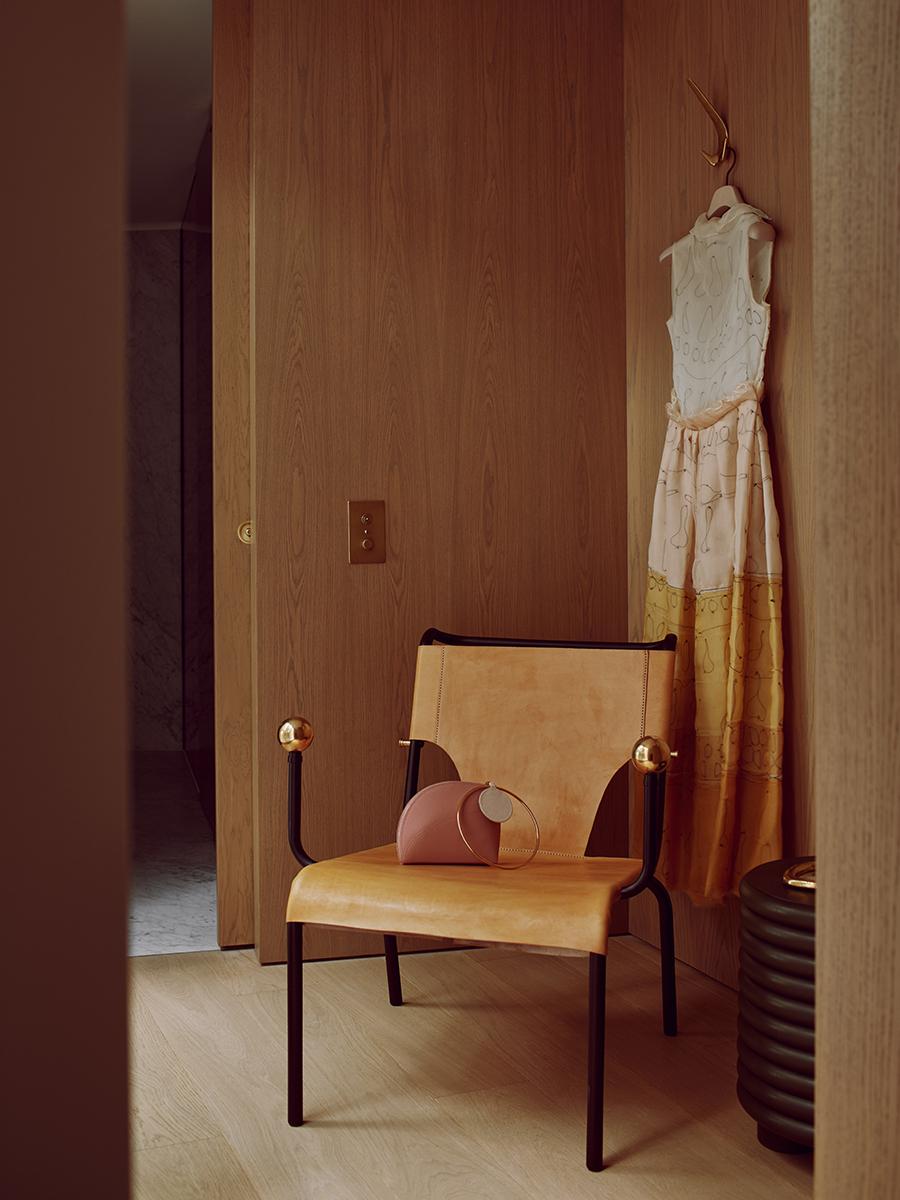 A Roksanda dress hangs behind a Lina Bo Bardi chair. (Photo: Michael Sinclair, styling: Olivia Gregory)