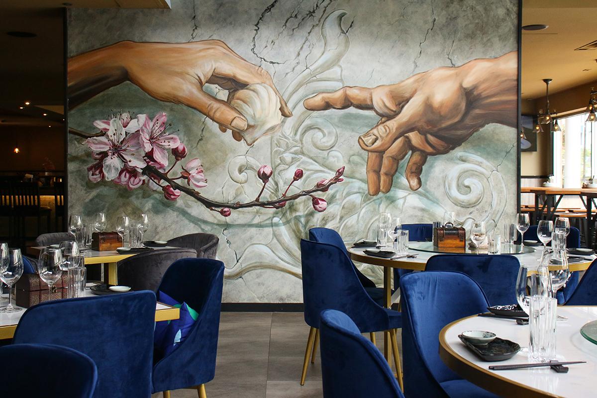 A Michelango-inspired mural by local artist Tyler Toews punctuates the dining hall of Blossom Dim Sum & Grill. (Photo: Johna Baylon)