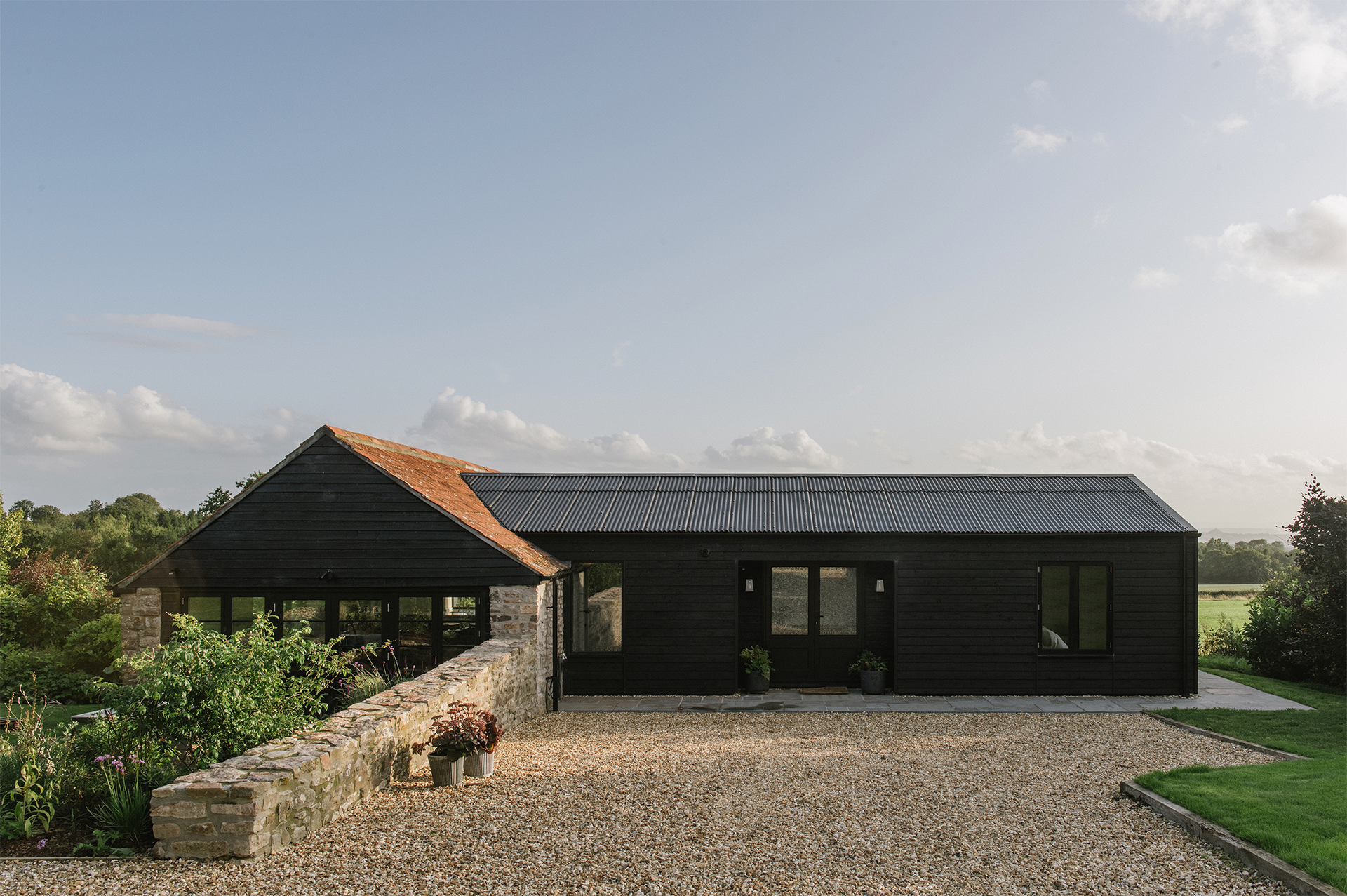 Explore a Charming English Barn Paired with a Timbre Clad Guesthouse