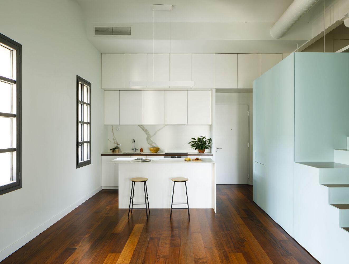 This blue wooden island turns a loft into a co-working and living space